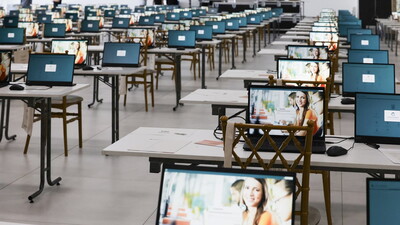 Prüfungsraum mit vorbereiteten IQUL-Laptops in langen Tischreihen für das volldigitale Zweite Juristische Staatsexamen in Rheinland-Pfalz