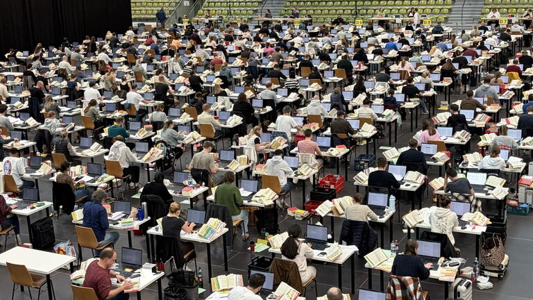 Several hundred candidates taking the electronic tax advisor exam 2026 in a large hall