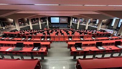 Ein moderner Hörsaal, vorbereitet für eine digitale Prüfung des Optikerverbands SWAV, mit Laptops auf den Tischen, bereit für die digitale Prüfung.